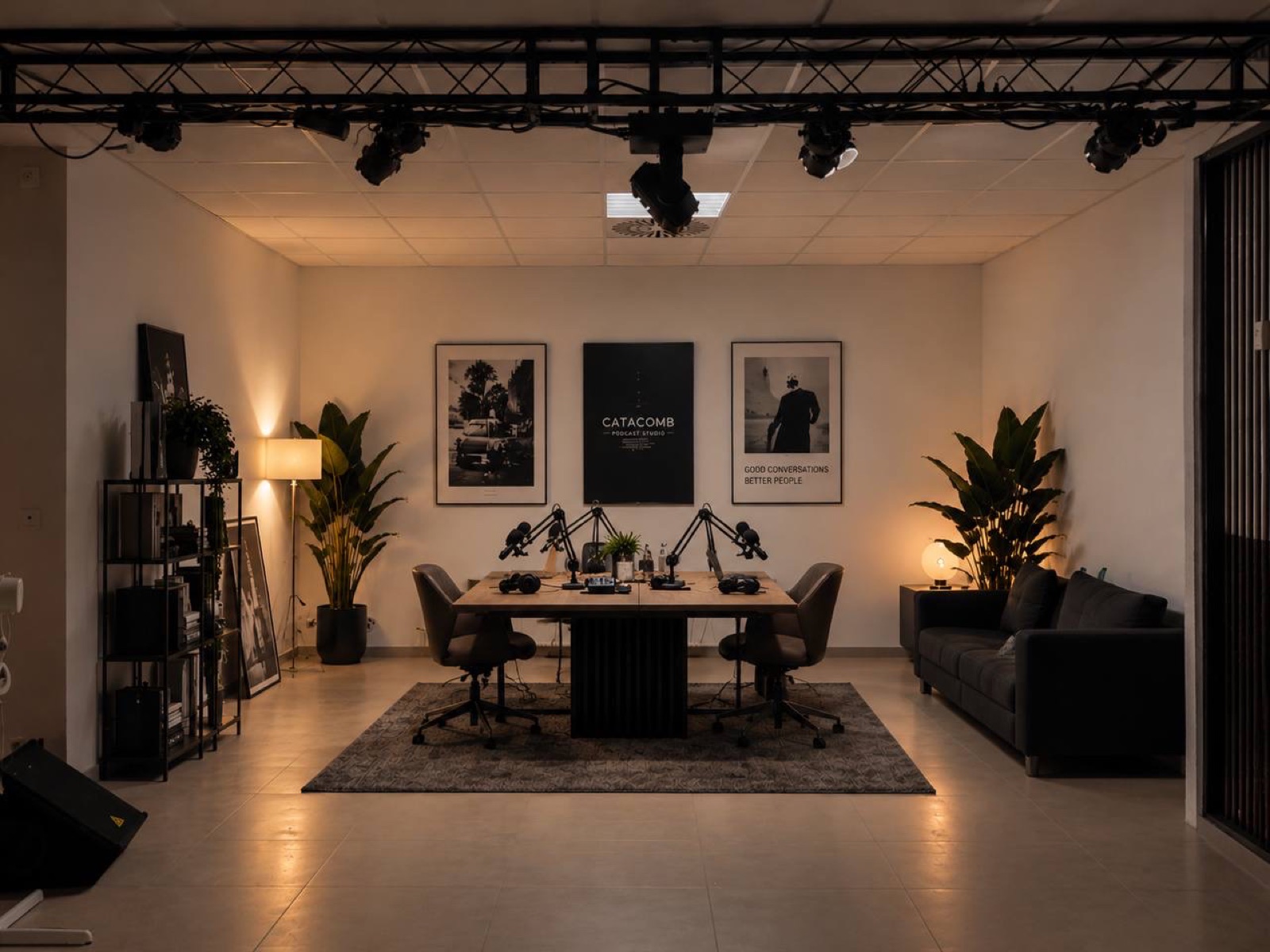 Podcast-Tisch bei Catacomb Studio mit vier Mikrofonen, Studiolicht und Ledersofa