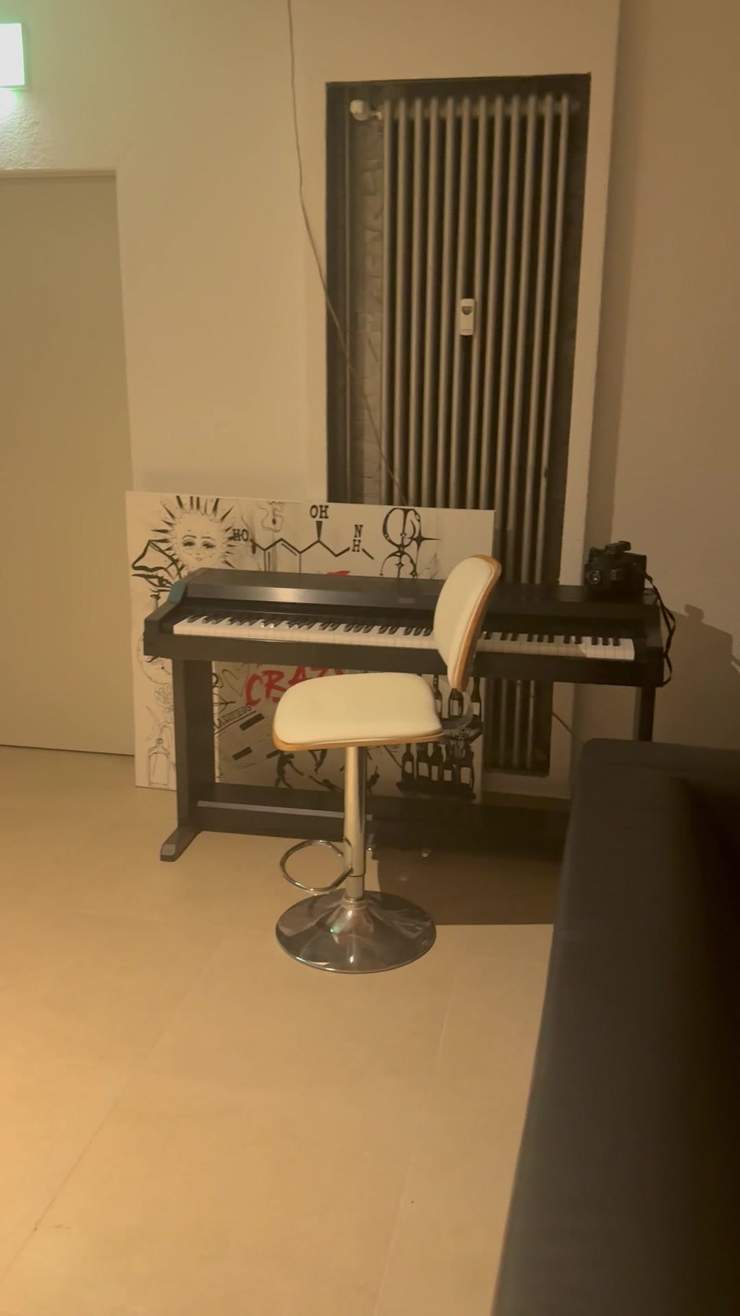 Klavier mit Hocker an der Wand der Lounge, daneben ein gemaltes Bild
