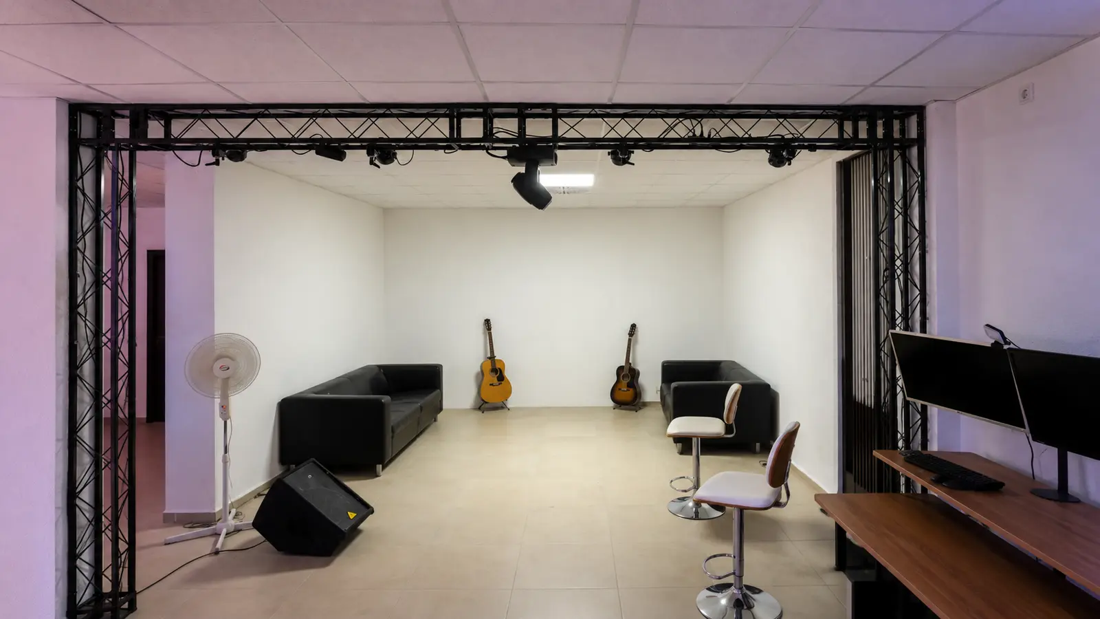 Leere Videoecke mit Traverse, heller Rückwand und flexibler Lounge-Ausstattung